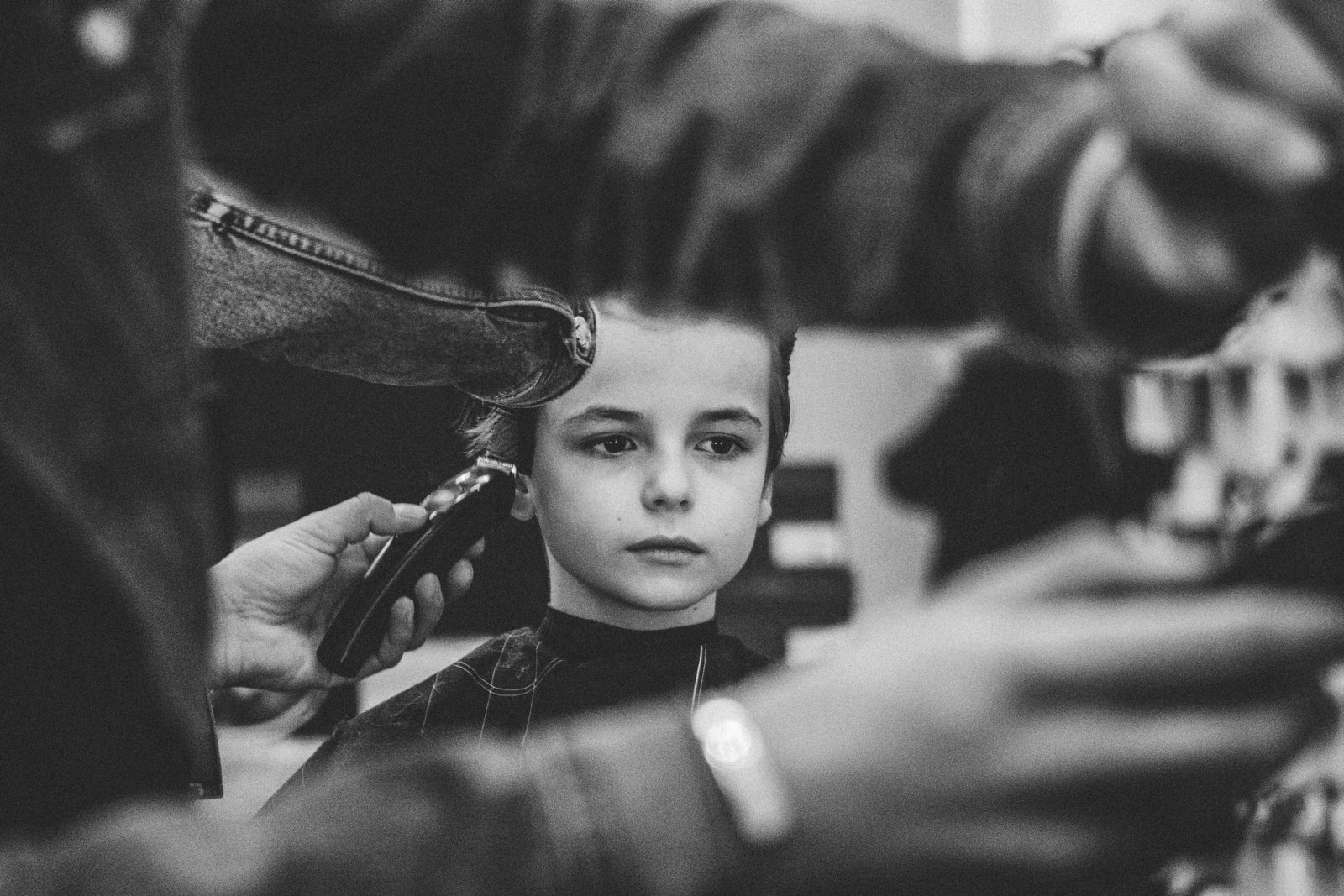 grayscale photo of boy having haircut